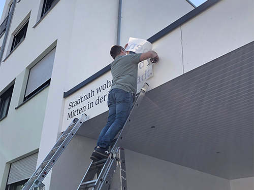 Ein Werbetechniker bringt den Schriftzug 