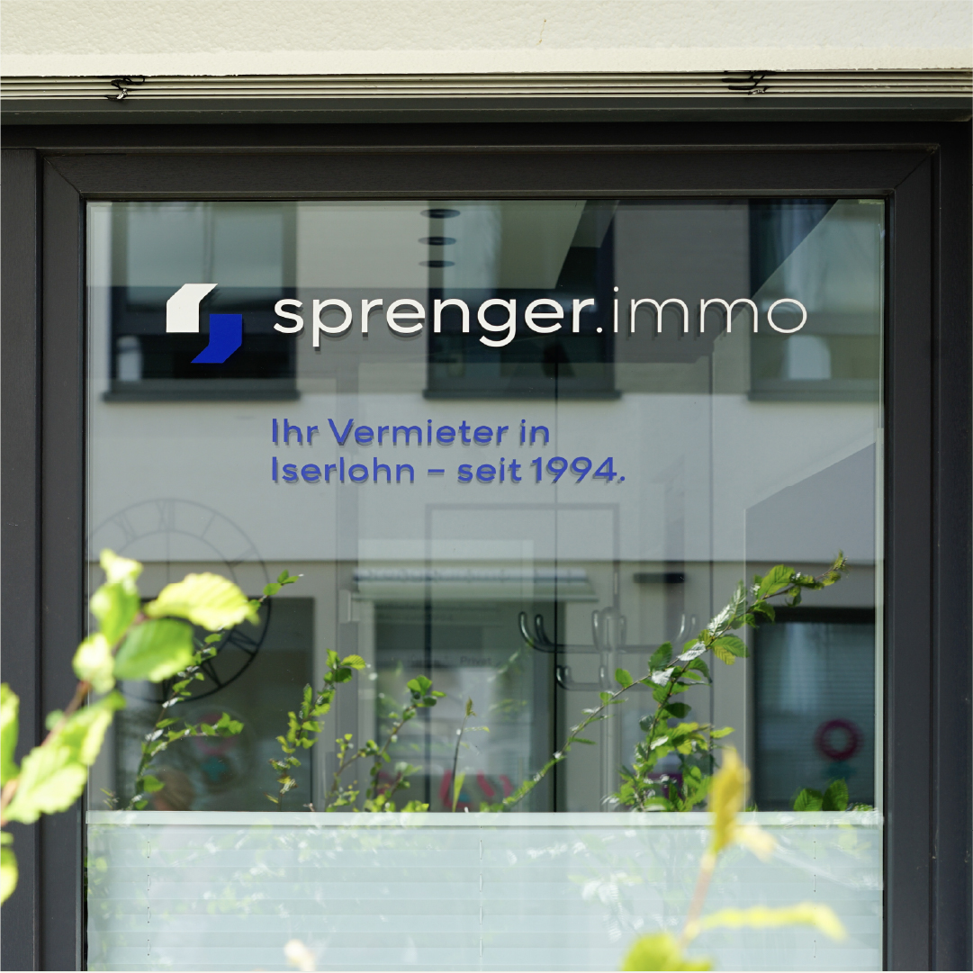 B&uuml;rofenster mit der Aufschrift sprenger.immo - Ihr Vermieter in Iserlohn - seit 1994.